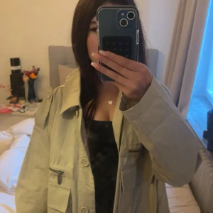 Beige overshirt från Kappahl - säljer en beige overshirt/tunn kappa från kappahl. bara använd 2 ggr och köpt för ungefär 2 år sedan.