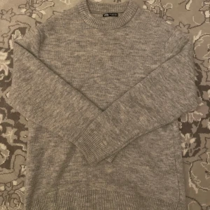 Stickad tröja - Zara - Mysig grå stickad tröja från Zara med rund halsringning och ribbade muddar. Stilren och håller dig varm, så blir perfekt nu inför vintern. Passar dig bäst som ligger runt 175-185. Inga defekter, som ny! Nypris 500. 