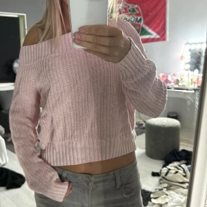 Ljusrosa offshoulder stickad tröja - Superfin ljusrosa stickad tröja med offshoulder och bred ribbad kant upptill. Croppad modell som sitter snyggt på och har långa ärmar. Perfekt för dig som gillar en chill och trendig stil. Mjuk och skön, passar till jeans eller kjol. Pris kan diskuteras 