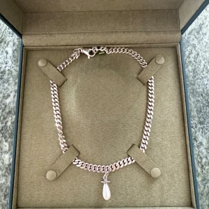 Silverhalsband med droppformad pärla - Stilrent halsband i silverfärgad metall med kraftig kedja och en hängande droppformad pärla. Perfekt för dig som gillar minimalistiska smycken med en elegant touch. Låses med karbinhake.