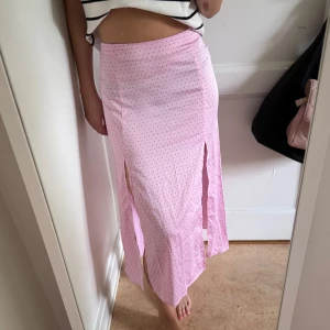 Rosa prickig långkjol  - Supersöt rosa långkjol från H&M med svarta prickar och två slitsar fram. 