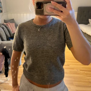 Grå stickad tröja från H&M - Mysig grå stickad tröja från H&M med korta ärmar och rund halsringning. Bara använt några enstaka gånger💕