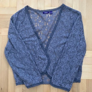 Blommig spetsblus från MEXX -  mörkgrå spetsbolero med blommigt mönster. Korta armar. 