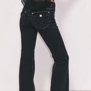 Svarta bootcut jeans med fickdetaljer - Svarta jeans med bootcut-silhuett och markerade sömmar. Snygga fickor bak med lock och silverfärgade knappar ger extra edge. Klassisk femficksmodell i stretchig denim som sitter skönt och formar snyggt. Har sprättat upp längst ner på grund av att dem var lite lite korta! Använda 1 gång. Pris kan diskuteras!❤️