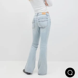 Ljusblå bootcut jeans med fickdetaljer - Snygga ljusblå jeans med bootcut passform och coola fickor med lock och knapp bak. Jeansen har klassisk femficksdesign och är tillverkade i mjukt denimtyg. Perfekta för dig som gillar en retroinspirerad look.