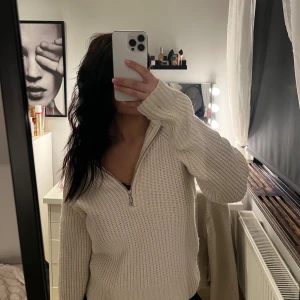  Stickad half zip tröja - Vit/beige stickad tröja med half zip-dragkedja och lång ärm. Finns en fläck på armslutet. Inget som stört mig, men kan nog lätt tvättas bort. 