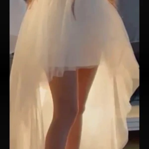 Vit asymmetrisk klänning i tyll - Supersöt vit klänning med asymmetrisk längd, kort framtill och lång baktill. Tillverkad i flera lager tunn tyll som ger en drömmig och fluffig känsla. Perfekt för dig som vill sticka ut med en unik och romantisk look.