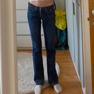 Levi's 557 blå bootcut jeans W27 L32 - Snygga blå Levi's 557 jeans med bootcut passform och klassiska detaljer som fem fickor och orange sömmar. Jeansen har låg midja och är tillverkade i slitstarkt denim. Köpta för ett par år sedan och är nu för små så därför väljer jag att sälja💞💞hoppas nån är intresserad 