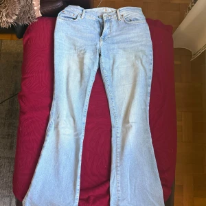 Ljusblå bootcut jeans från gina tricot - Snygga ljusblå jeans från gina tricot jeans i klassisk bootcut-modell. Jeansen har fickor, orangea kontrastsömmar och en bekväm passform. 