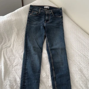 Blå skinny jeans från Zara - Snygga blå jeans från Zara i klassisk skinny fit. Jeansen har fem fickor, orangea kontrastsömmar och normal midja. Tillverkade i stretchigt denim som sitter tajt längs benen och ger en smickrande siluett.