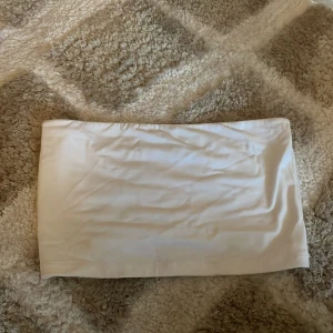 Vit bandeau tubtopp - Bandeau topp från Gina, har aldrig kommit till användning. Den sitter som en M kanske passar S också för den är i storlek xl egentligen men har sytt in den på sidorna då den var för stor 💕så nu sitter den som en M 