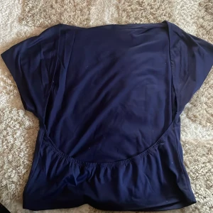 Mörkblå T-shirt med öppen rygg  - Mörkblå topp med öppen rygg i XL men skulle säga att den är en M/L