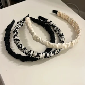 3-pack scrunchie-diadem i svart och vitt - Säljer tre snygga scrunchie-diadem i svart, vitt och svartvitt mönster. De är täckta med mjukt tyg och har en trendig, rynkad look som ger en cool touch till din outfit. Perfekt accessoar för att lyfta håret och stilen.