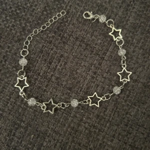 Armband med stjärnor och pärlor -  armband i silverfärg med öppna stjärnformade länkar och genomskinliga pärlor. Justerbar kedja med karbinlås  (inte äkta silver)