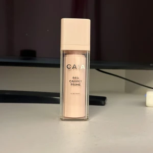 CAIA Red Carpet Prime primer - Glow primer från CAIA i en snygg ljusrosa pumpflaska med genomskinlig ytterförpackning. Perfekt för att ge huden en fräsch och strålande bas innan sminket. Enkel att applicera och ger en jämn finish. Jag är öppen för prisförslag