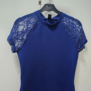 Blå blus med spetsärmar - Snygg blå blus med korta ärmar i transparent spets. 