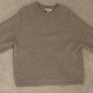 Beige stickad tröja från & Other Stories - Supermjuk beige stickad tröja från & Other Stories i storlek XS. Tröjan har rund hals, trekvartsärm och en loose passform som ger en chill vibe. Perfekt för lager-på-lager och snygg till jeans eller kjol. Färgen är ljusbeige och materialet känns riktigt skönt mot huden. Nästan oanvänd då jag inte använder och ligger i garderoben istället! Kan tänka mig 200 kr