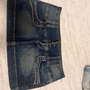 Super snygg jeanskjol - Cool jeanskjol från TRF Denim Rules i mörkblå denim med slitningar, dekorativa knappar och fickor både fram och bak. Kjolen har en unik leopardmönstrad detalj och leopardkant på insidan. Den är M men passar mig som har storleken S. 