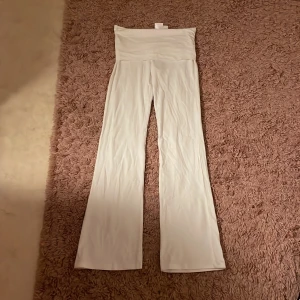 Vita vida byxor från Gina Tricot - Snygga vita byxor från Gina Tricot med hög midja och vida ben. Tillverkade i mjukt och stretchigt material som sitter skönt. Perfekta för en chill och trendig look.