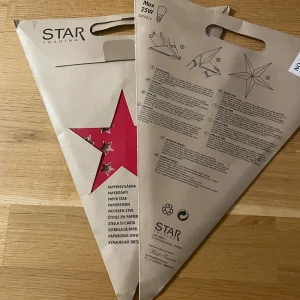 Paper Star Decoration - 2 Röda pappersstjärnor från Star Trading, perfekt för fönsterdekoration. Levereras i originalförpackning med instruktioner. Max 25W E14-lampa. Produkten är oanvänd, idealisk för jul eller mysig belysning.