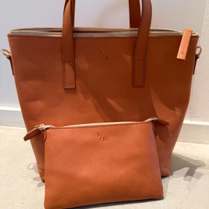 Sandlund/Hossain - Väska från Sandlund/Hossain med tillhörande plånbok. Väskan är knappt använd, utmärkt skick. 