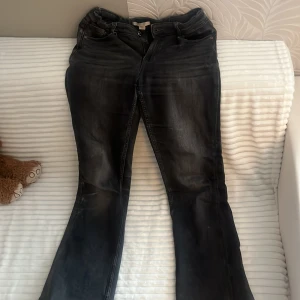 Svarta bootcut jeans från Gina Tricot - Säljer ett par svarta bootcut jeans från Gina Tricot i storlek 158. Jeansen har en snygg tvättad look och klassisk femficksdesign. Perfekta för dig som gillar en lite vidare passform nertill och vill ha en cool vardagsstil.