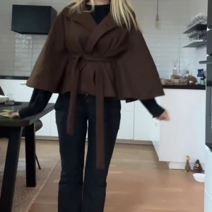 Brun poncho/kappa - Säljer min bruna poncho/kappa då den ej kommer till användning, perfekt skick precis som ny, jättefin och mysig.