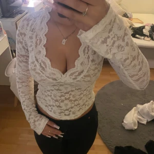 Vit spetsblus från Vero Moda - Säljer en vit långärmad blus från Vero Moda i storlek S. Blusen är helt i spets med blommigt mönster, djup v-ringning. Och är i nyskick och använd 1 gång max. Supersnygg att styla med jeans eller kjol och passar till de mesta, skriv gärna frågor om du har, inga nopprar och inga defekter 
