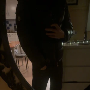 Svart Moncler pufferjacka herr - Säljer en svart pufferjacka från Moncler med klassisk logga på ärmen. Jackan har dragkedja framtill och en stilren, vadderad design som håller dig varm. Perfekt för dig som vill ha en snygg och trendig vinterjacka.