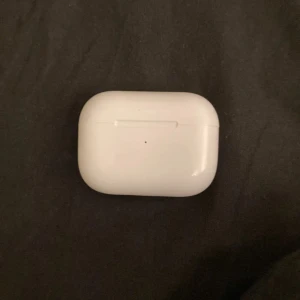 AirPods Pro - Snygga AirPods Pro. Trådlösa hörlurar med aktiv brusreducering och bekväm passform. Laddningsindikatorn fungerar och inga synliga repor eller skador. Perfekt för musik, samtal och träning.