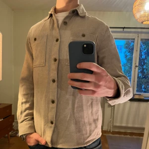 Beige Dobber Overshirt  - Säljer denna sjukt snygga Overshirten från Dobber⭐️ Färgen är beige och storleken är M✅ Den har inga defekter och skicket är utomordentligt🙌🤝 Sjukt najs passform och passar perfekt till hösten🍁🙌 Tveka inte på att höra av er dig vid minsta fråga eller fundering😊