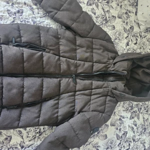 Brun quiltad pufferjacka H&M XS - Säljer en brun pufferjacka som har quiltad design, huva och två dragkedjeförsedda fickor framtill. 