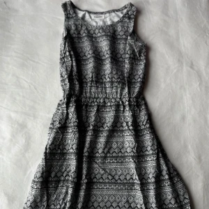 Svartvit klänning - Klänning med svartvit geometriskt mönster från Kappahl. I storlek 140. Fraktar inom 24h!