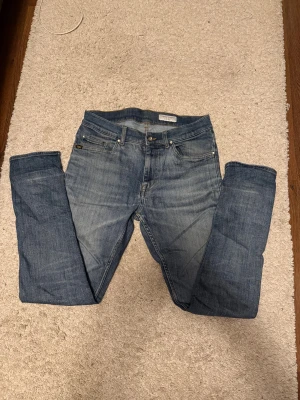 Tiger of Sweden Evolve jeans blå 30/30 - Snygga blå jeans från Tiger of Sweden, modell Evolve. Klassisk femficksdesign med bruna sömmar och läderpatch bak i midjan. Jeansen har en rak passform och är tillverkade i slitstarkt bomullsmaterial. Perfekt för dig som gillar stilrena och tidlösa jeans. Köpta för 1500kr på Tiger of Sweden i Åhléns.