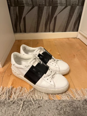 Valentino Garavani Open sneakers - Säljer ett par snygga Valentino Garavani Open sneakers. Säljer de pga jag använder de för lite och d ger mig lite skav. Tycker själv de är i ett riktigt bra skick, det ända är en liten skråma på höger sko framtill. Kan tänka mig att gå ner lite i prid vid en snabb affär. De är såklart äkta. Hör gärna av er vid fler frågor!