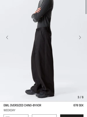 Svarta oversized chinos Weekday - Säljer ett par svarta oversized chinos från Weekday i modell Emil. Byxorna har riktigt bred passform, hög midja och raka ben. Tillverkade i ett mjukt bomullsmaterial med klassiska fickor och hällor för bälte.  Avslappnad och trendig. Använda en gång :)