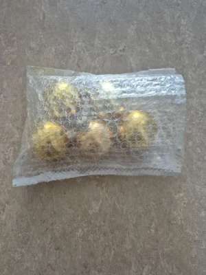 Julkulor - Säljer ett gäng klassiska julgranskulor i blank guldfärg. Kulorna är runda och har metallfäste för upphängning. Perfekta för att ge granen en lyxig och glansig touch till julen. Levereras i bubbelplast för extra skydd.