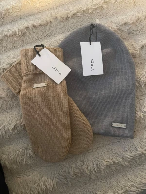SÄTILA mössa och vantar - Säljer  en mössa i grått och ett par stickade vantar i beige från Sätila, helt nya med pris lapp och aldrig används. Säljer billigt!!💗💗