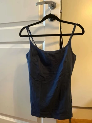 Mörkblå linnetopp med justerbara band - Marinblått linne med resårband på axelbanden. I storlek L, men skulle nästan säga att det är M-L
