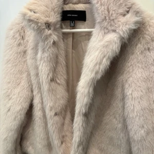 Beige pälsjacka från Vero Moda - Säljer en fluffig och supermjuk beige pälsjacka från Vero Moda. Jackan har en klassisk krage, knappar framtill och är helfodrad för extra komfort. Perfekt för dig som vill ha en varm och stylish look under kyliga dagar vinter som vår.
