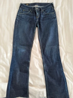 Mörkblå jeans från Lee - Ett par mörkblå Lee jeans med rak passform i storlek W30 L25 ( S ). Dock klippta på längden. Använda en hel del men i sjukt bra skick! Säljer eftersom dem blivit för små🩷.     Innerbenslängd: 78cm.       Höft till höft: 40cm.     Nypris: 899kr
