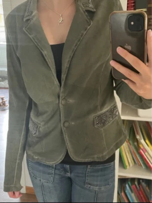 Olivgrön kavaj från Two Wings - Säljer en olivgrön kavaj från Two Wings med coola detaljer som nitar på kragen och fickorna. passar Xs S