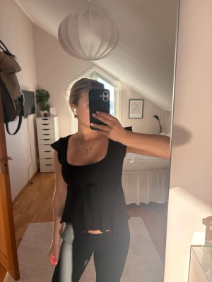 Svart topp från Nelly🫰🏼 - Supersöt svart topp från Nelly med volangärmar och knyt i midjan. Storlek xxs men inte så liten i storleken💕använd fåtal gånger