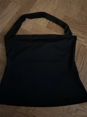 Svart axelbandslös topp  - Säljer en svart jätte snygg topp från Nelly, bara använd 1 gång!