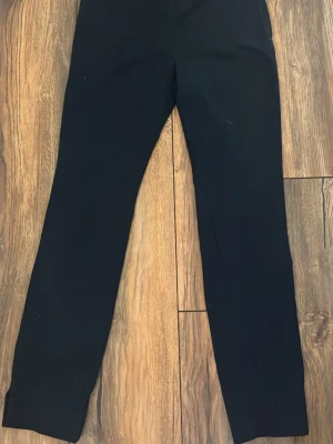 Svarta kostymbyxor från Zara Woman XS - Snygga svarta kostymbyxor från Zara Woman i storlek XS. Byxorna har raka ben, bälteshällor och diskreta bakfickor. Perfekt för dig som gillar stilrena och klassiska plagg. 