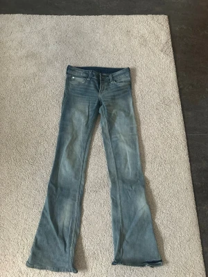 Bootcut jeans från Cheap Monday 28/34 - Säljer ett par ljusblå lågmidjade bootcut jeans från Cheap Monday med snyggt Cheap Monday-märke på bakfickan. Jeansen är helt oanvänd och är i mycket fint skick!