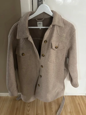 Beige overshirt jacka från ONLY - Säljer en beige kappa från ONLY i storlek s. Säljer den då den inte kommer till användning, den är använd fåtal gånger så nästan som ny🥰