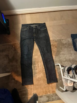 Nudie jeans - Ett par nudie jeans i storlek 31:34. Jag skulle säga att de passar ungefär 30:32. De är avskurna i botten som man ser på bild men eftersom de är formade efter uppvikning påverkar detta inte användning annat än att om man kollar ser man att det ej är sömmar i botten. Har valt det billiga priset utifrån detta.