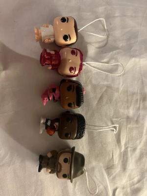Kinder joy stranger things figurer  - Bilderna visar små samlarfigurer från stranger things med snöre för upphängning, figurerna är eleven, hopper, Erika, Lucas och Max 