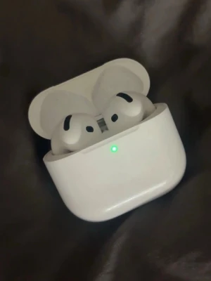 AirPods 4 - Snygga och populära Apple AirPods 4med laddningsetui. Trådlösa hörlurar med aktiv brusreducering och bra batteritid. Skicket ser mycket bra ut utan synliga repor eller skador. Perfekt för musik, samtal och träning.